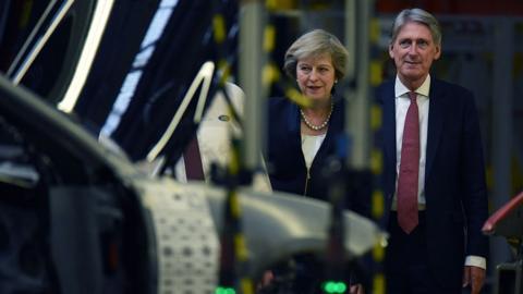 Theresa May and Philip Hammond in car factory