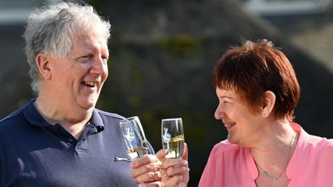 Michael Williams and Marion Wood toast their £1m lottery win with glasses of champagne