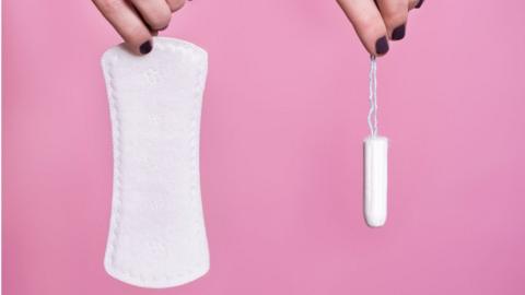 Women's hands holding sanitary products