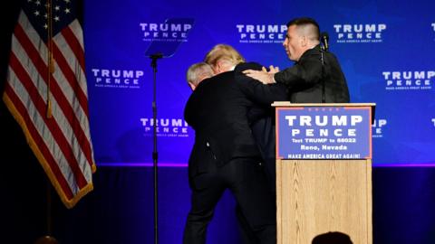 U.S. Republican presidential nominee Donald Trump is hustled off the stage by security agents after a perceived threat in the crowd, at a campaign rally in Reno, Nevada, U.S. November 5, 2016