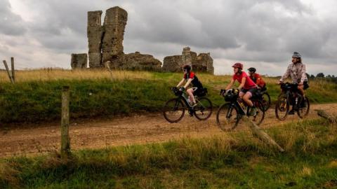 Riders going past the ruined church of St James in Bawsey, Norfolk,on the Rebellion Way
