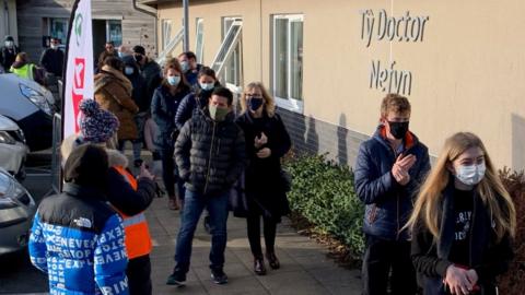 People queue to receive their Covid vaccine on Sunday at a GP practice