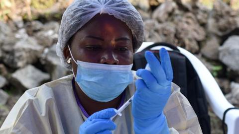 A Congolese health worker prepares to administer an ebola vaccine to a man at the Himbi Health Centre in Goma