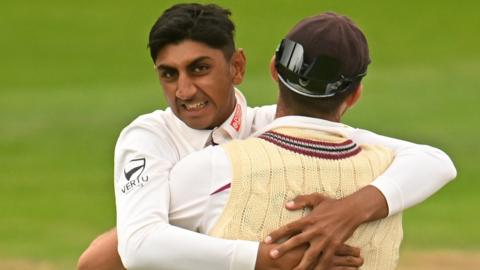 Somerset spinner Shoaib Bashir embraces a team-mate to celebrate taking a wicket