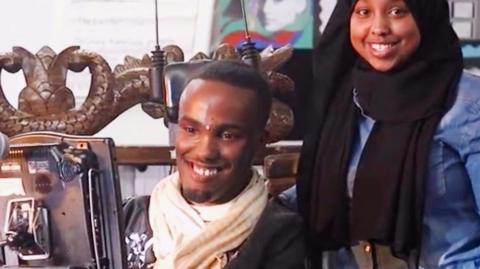 Abdi Omar in a wheelchair with wife Maria