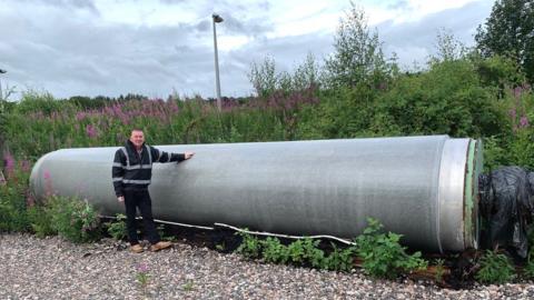 Graeme Sutherland, formerly of Thomas Tait and Sons, stands beside the 50 tonne granite roll