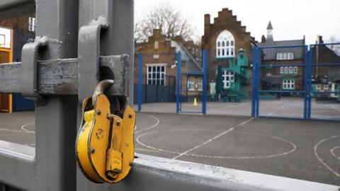 A lock hangs on a primary school gate in Deptford on January 04, 2021 in London, England