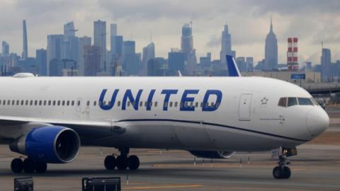 A United Airlines airplane proceeds to a gate at Newark Liberty International Airport in front of the skyline of midtown Manhattan and the Empire State Building in New York City on January 27, 2024, in Newark, New Jersey.