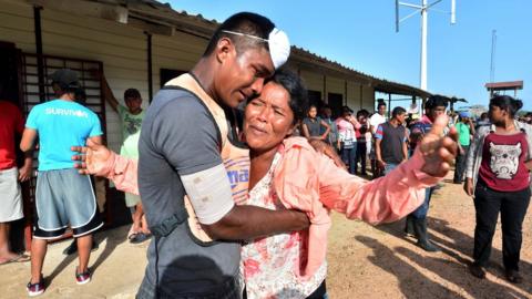 A survivor of a capsized boat is embraced by a relative in Puerto Lempira, Honduras, 4 July 2019