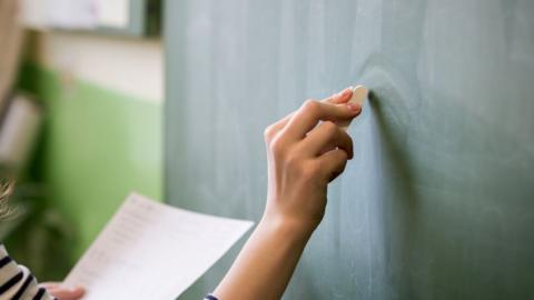 Teacher writing on blackboard