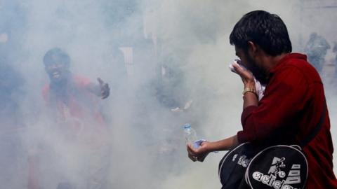 Protesters amongst the smoke of tear gas