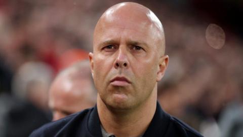 A close-up head shot of Arne Slot at Liverpool FC's Anfield stadium.