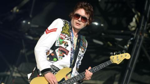 Nicky Wire on stage playing his bass guitar