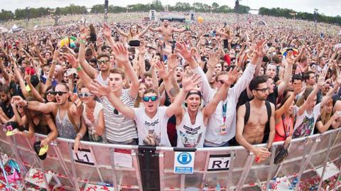 A shot of a large crowd with their hands aloft at a live concert