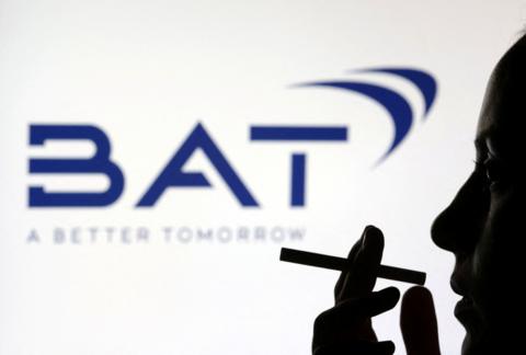 Silhouette of a person holding a cigarette in front of a dark blue BAT logo on a white background