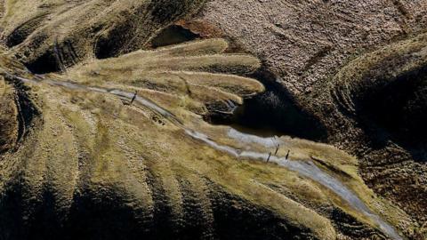 Drone shot of a former spoil tip now grassed over and forming a pattern like fingers on the landscape