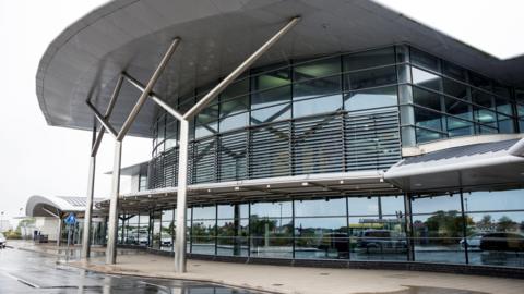 An exterior view of Guernsey Airport - a big glass-fronted building