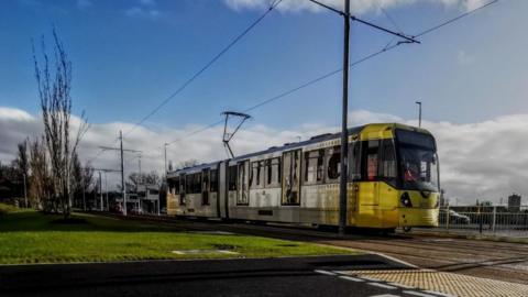 Metrolink tram approaches a road junction.