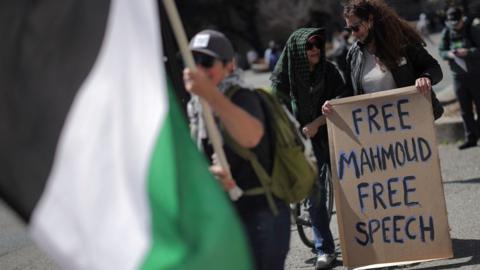 Demonstrators hold a sign as people attend a protest following the arrest by US immigration of mahmoud khalil.