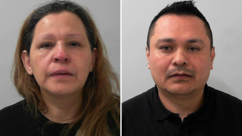 Two custody photos side by side. On the left is a woman with long brown hair and brown eyes wearing a black top in front of a grey background. On the right is a man with short dark hair, dark eyes and stubble wearing a black top in front of a grey background.