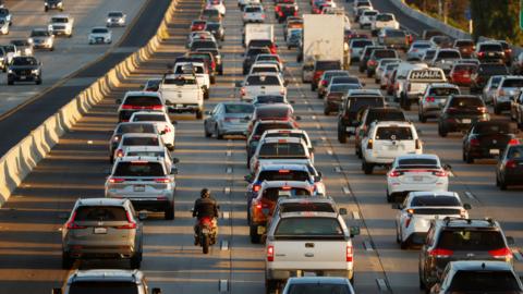 A motorcyclist lane splits as traffic backs up on Interstate 5 during the afternoon commute on November 7, 2025 in San Diego CA.