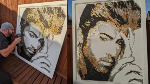 Two images of the portrait of singer George Michael created using screws coloured silver, gold and black. It depicts the star as he was in the 80s, with his signature hairstyle. The picture on the right shows the bearded artist - who is wearing a black t-shirt and grey beanie drilling a screw into the left hand side of the canvas.