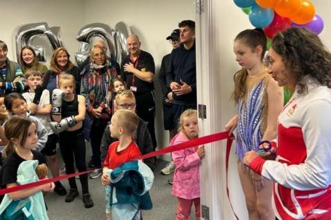 Rhythmic gymnast Mimi-Isabella Cesar (left) prepares to cut the ribbon