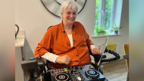 Sue, pictured with DJ decks on her lap