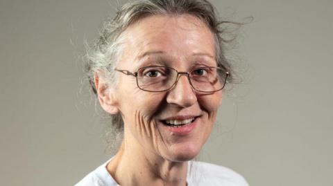 Wendy Bearton in a pair of glasses and white T-shirt