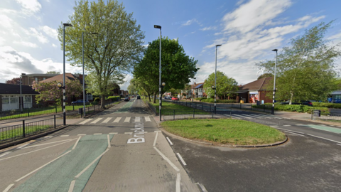 The crossing where the incident happened. There is a zebra crossing stretching across a carriageway with a grassy central reservation.