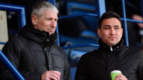 Jez George, left, and Liam Scully, in the stands looking towards the pitch