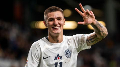 Benjamin Sesko holds up three fingers to celebrate a hat-trick after scoring Slovenia's third goal during the UEFA Nations League tie for Slovenia against Kazakhstan 
