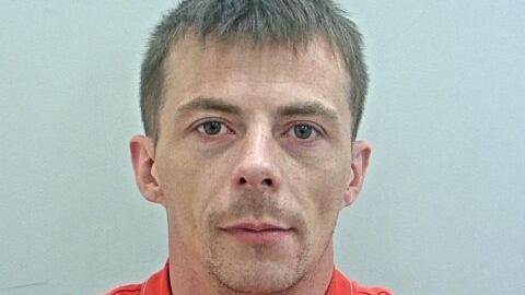 Mugshot of Daniel Robinson in an orange top