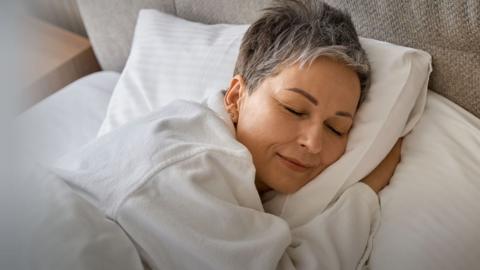 A woman snuggled up in bed