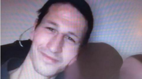 Head and shoulders of a man who is smiling and looking into the camera. 