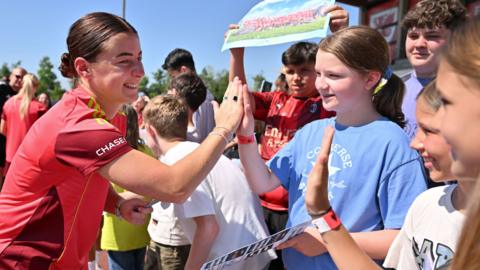 Wales' Angharad James high-fives local children