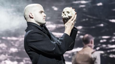 Actor Ralph Davis holds a skull aloft in the Royal Shakespeare Company's performance of Hamlet. 