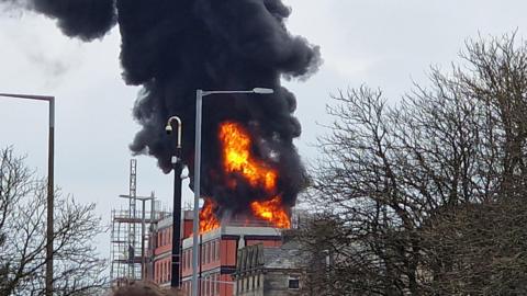 Plumes of black smoke billow into the sky as a fire sweeps through a construction site of new flats on Parliament Street, Lancaster