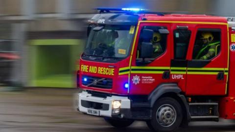 Fire engine with blue lights on travelling at speed