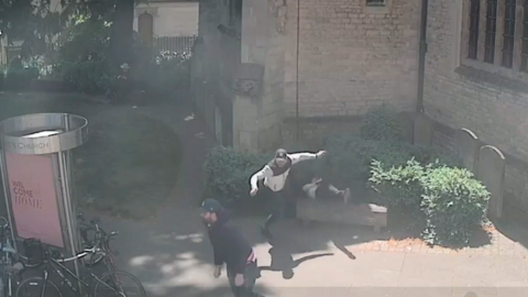 Two men wearing baseball caps run away from a church, where a man has fallen backwards off a bench.