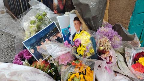 Floral tributes and images left in memory of Harry Calam 