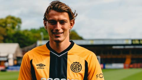 Zak Bradshaw wearing a Cambridge United shirt