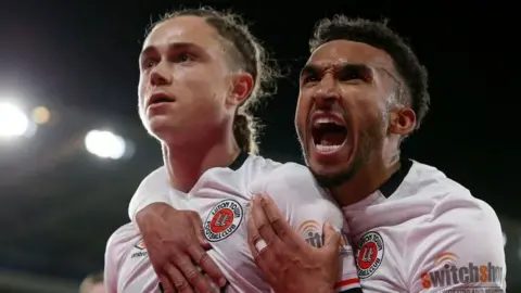 Luton celebrate their winning goal at Cardiff 