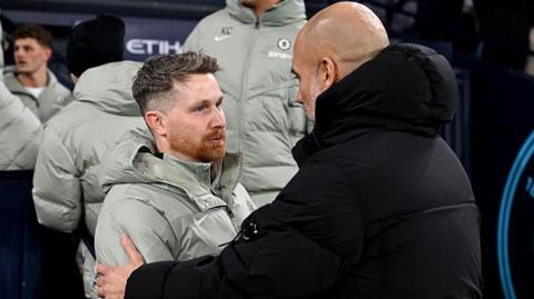 Calum McFarlane embraces Pep Guardiola after drawing at Manchester City earlier in the season