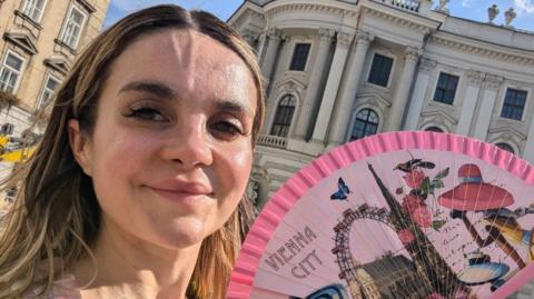 Girl with dark blonde hair with Vienna City themed fan