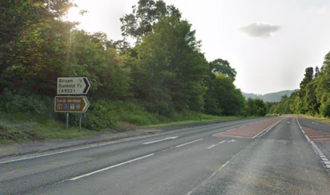An empty dual carriageway with a road sign for Dunkeld and Birnam