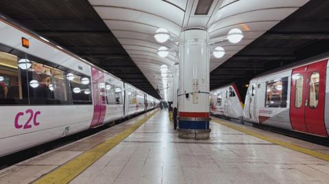 A c2c class 357 train and a Greater Anglia class 720 train at London Liverpool Street station, with a platform separating the two trains.