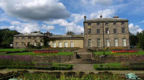 Country house with gardens and flowers in front of the property

