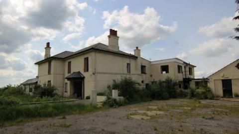 The current site of the vacant Mablethorpe Hall building, no longer with windows and overgrown grass surrounding it