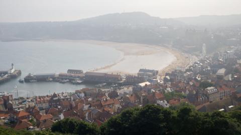 Scarborough beach and pier, pictured from above on a misty day.